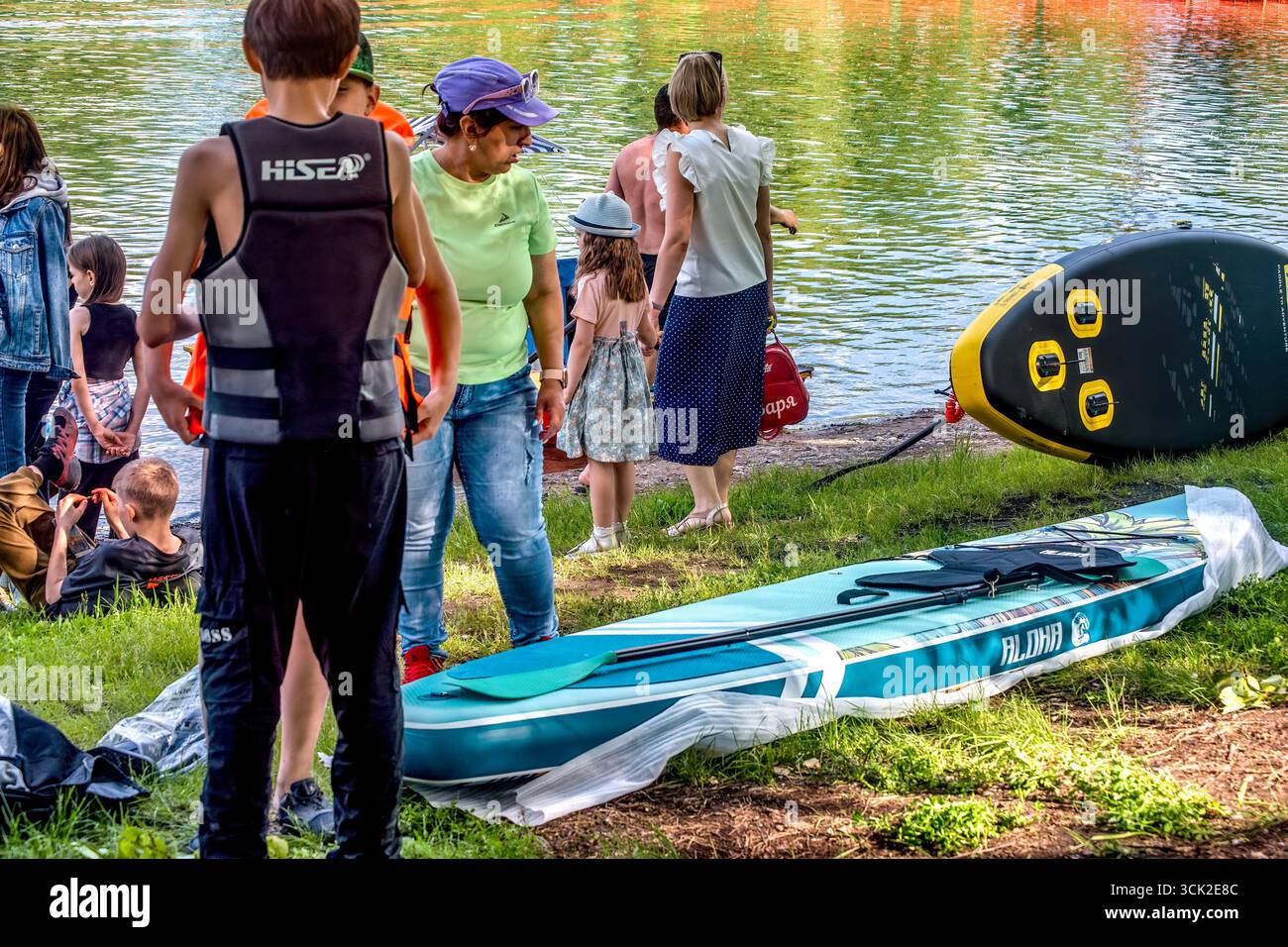 La gente prepara una barca per il surf SUP sul lago in estate: Abakan, Russia - 8 giugno 2024 Foto Stock