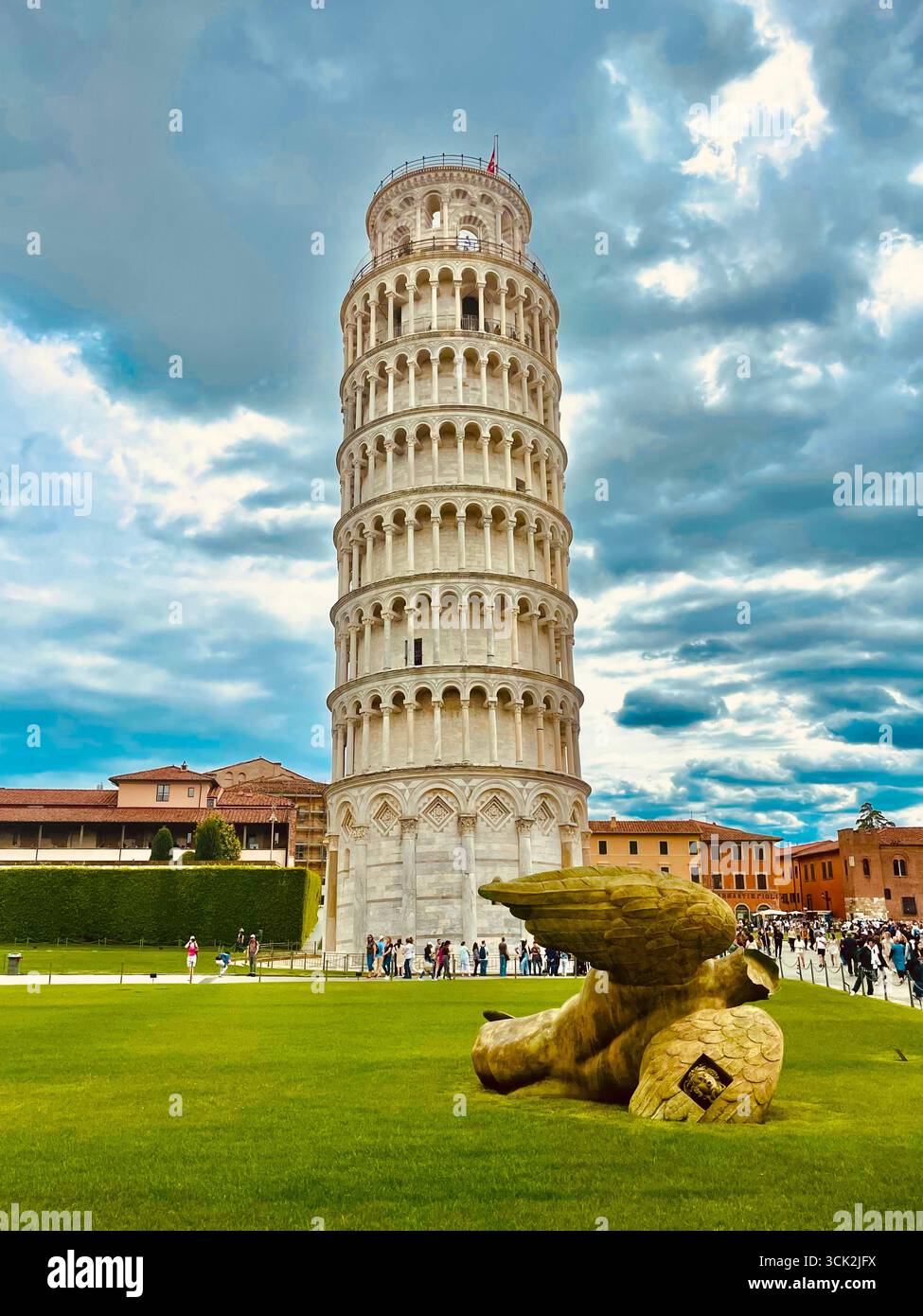 Angelo caduto di Igor Mitoraj sul prato di Piazza del Duomo accanto alla Torre Pendente di Pisa, Italia. Arte moderna in contrasto con un punto di riferimento storico - Immagine stock catturata con smartphone