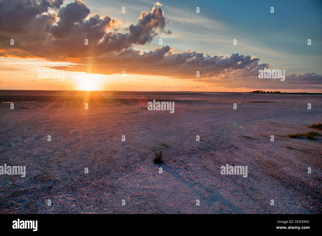 africa turismo, tramonto pianura desertica, cielo arancione con nuvole all'orizzonte, solitudine in una regione remota Foto Stock
