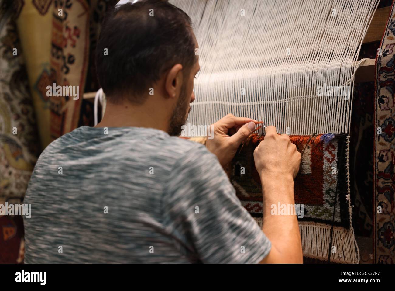 L'artigiano siriano dimostra la tradizionale tessitura a mano alla Fiera Internazionale di Damasco. Un tessitore siriano espone l'artigianato della produzione tessile tradizionale all'interno della Fiera Internazionale di Damasco. I legami artigianali si intrecciano a mano per creare un tappeto a motivi geometrici, che riflette il patrimonio secolare della tessitura siriana preservato nonostante anni di conflitto. Damasco Siria Copyright: XMohammadxBashirxAldaherx Foto Stock