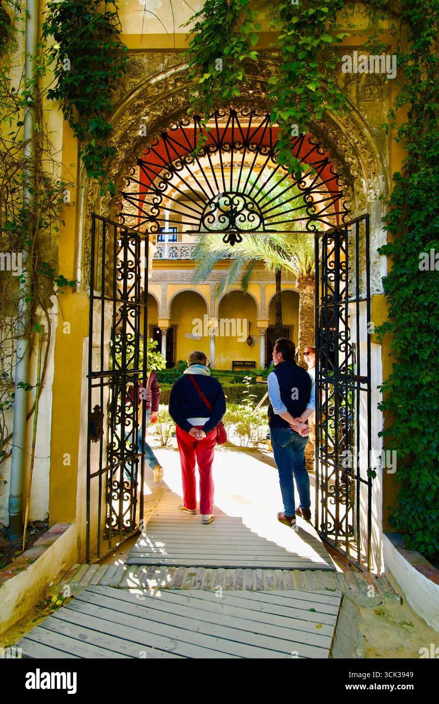 Porte d'ingresso in ferro e arco del cortile principale con archi a colonne e una galleria Palacio de las Dueñas Casa di Alba Siviglia Andalusia Spagna Foto Stock