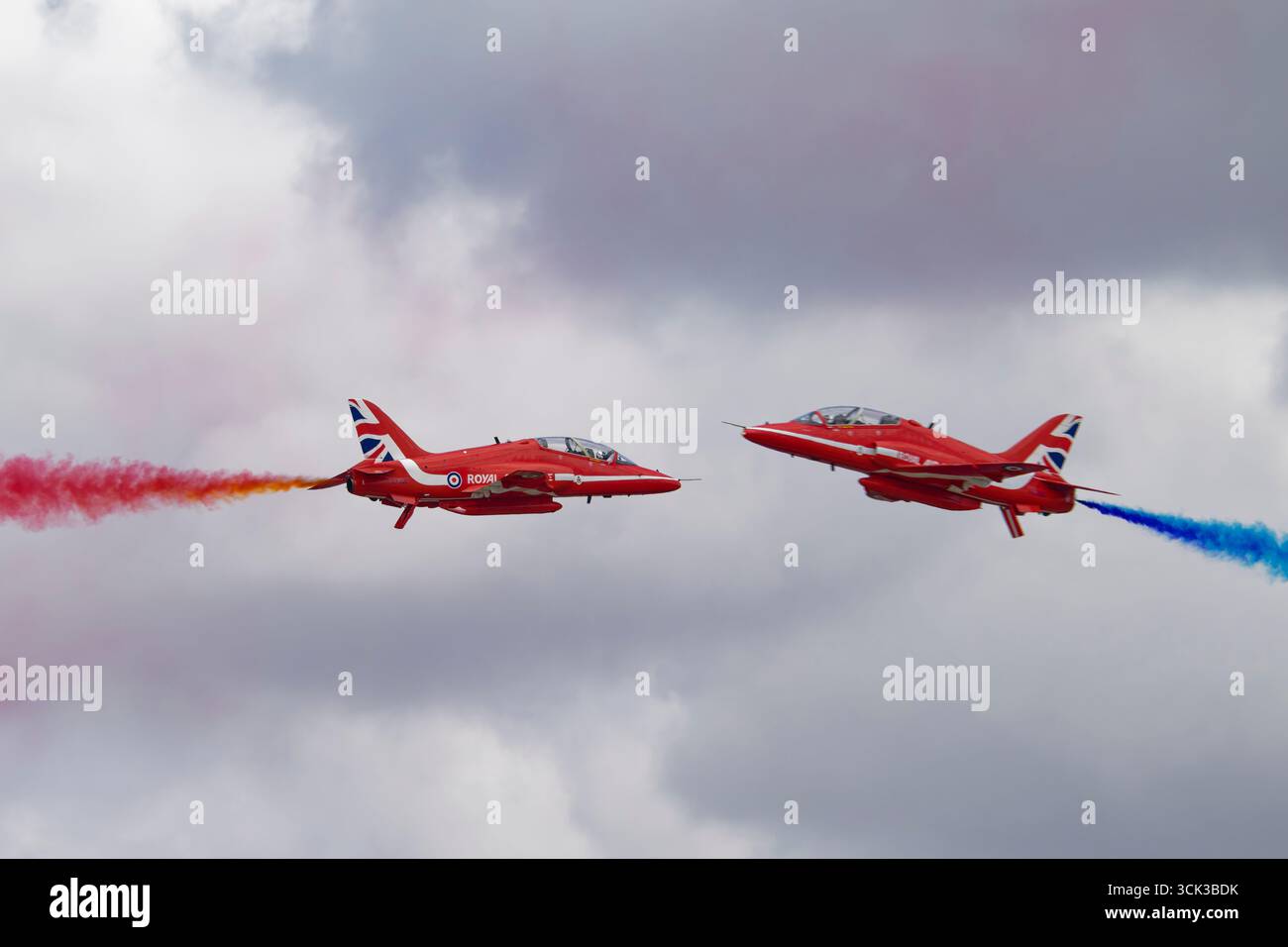 Due BAE Hawk Advanced Jet Trainers della RAF Red Arrows eseguono un passaggio di opposizione ravvicinato durante il Royal International Air Tattoo Foto Stock