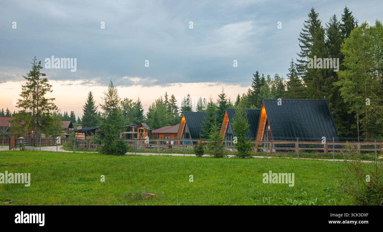 Incantevole rifugio in una capanna immersa nel pittoresco paesaggio rurale e negli alti abeti rossi vicino a Borzont, nei Carpazi, in Romania. Foto Stock