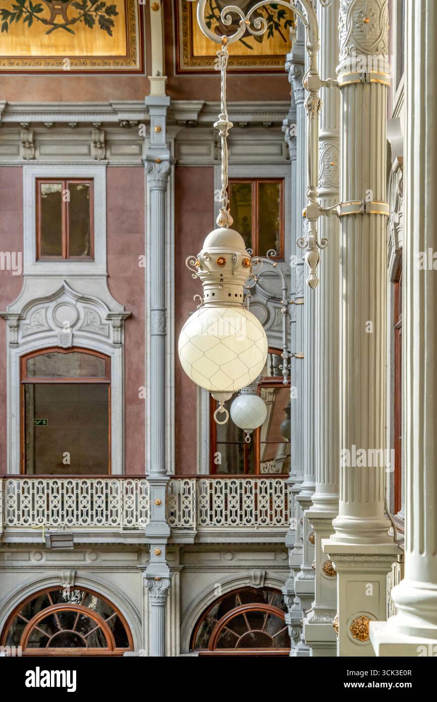 Elegante lampada sospesa all'interno del Palazzo della Borsa, o Palacio da Bolsa a Porto, con decorazioni in metallo e architettura classica. Colonne corinzie Foto Stock