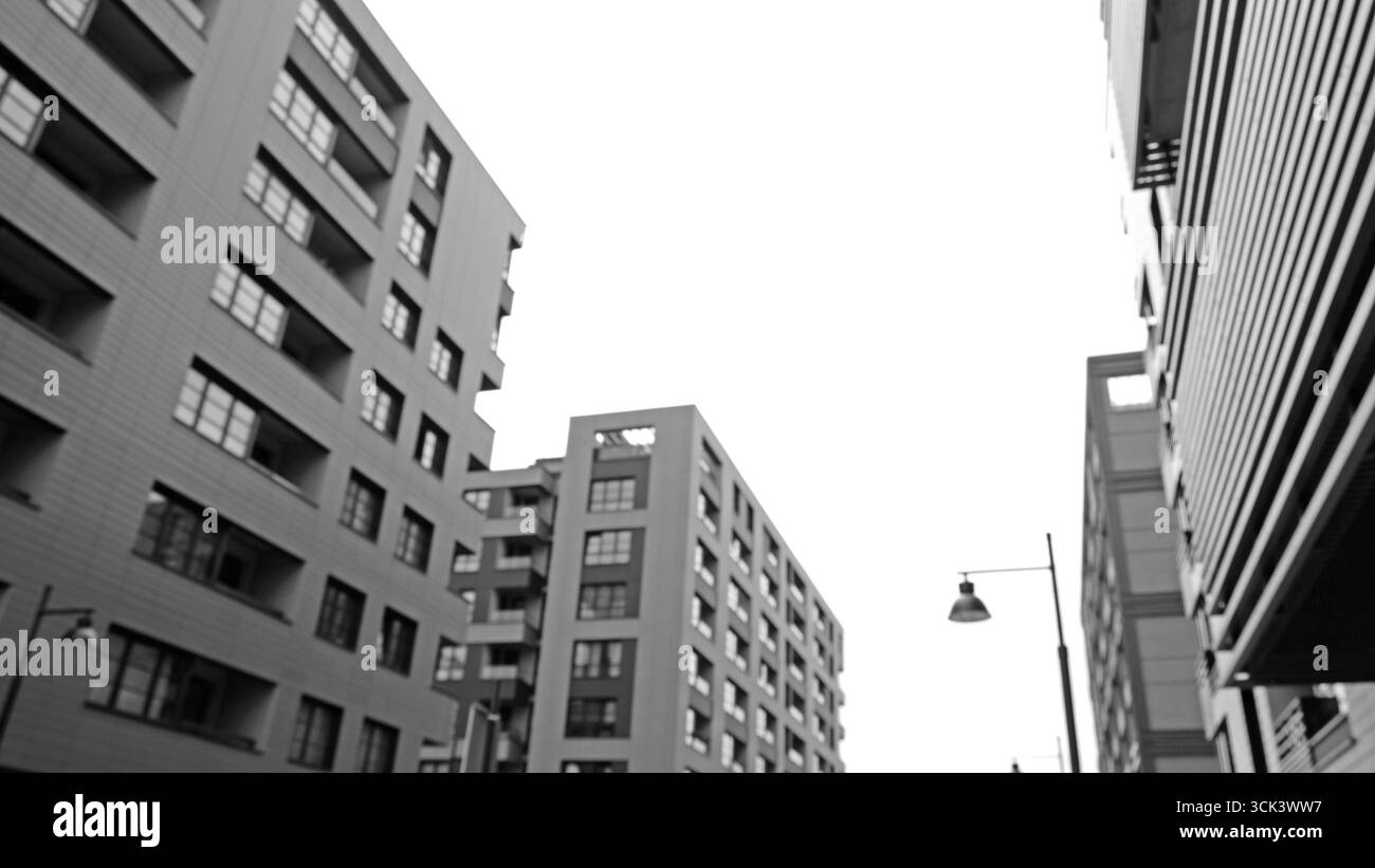 Immagini sfocate, in bianco e nero, ad angolo basso, di edifici di appartamenti moderni. Architettura urbana, forme geometriche. Immobili, appartamenti residenziali Foto Stock
