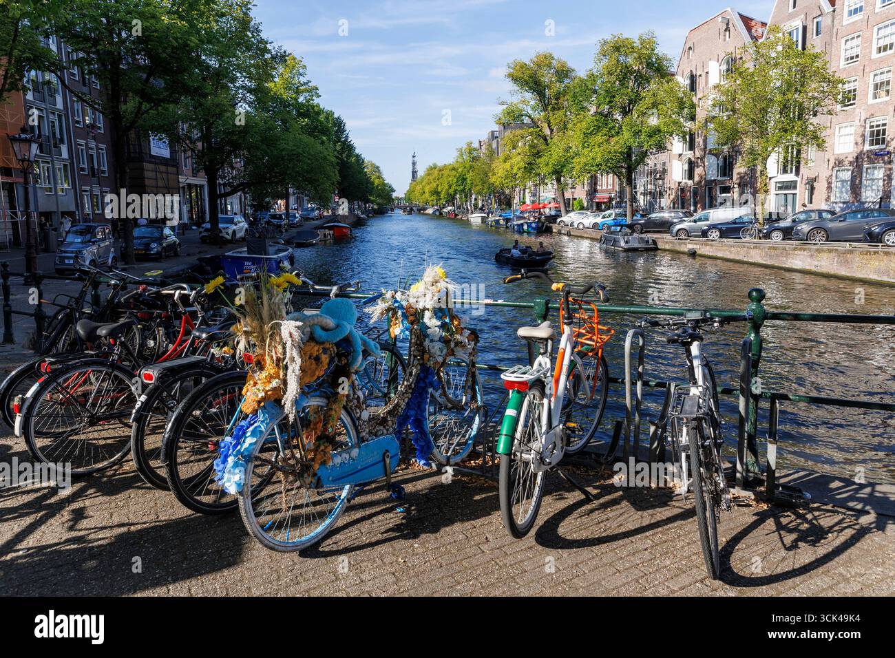 Bancarelle per biciclette decorate sul ponte sul canale Prinsengracht nel centro della città, Amsterdam, Paesi Bassi. Geschmuecktes Fahrrad steht auf einer Bruecke An Foto Stock