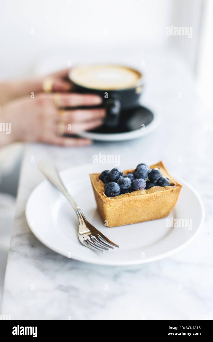 Cappuccino con motivo a base di schiuma di latte nelle mani delle donne Foto Stock