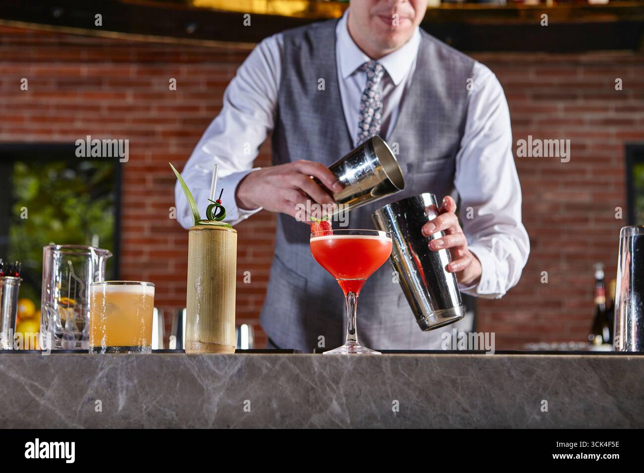 Barista mescola un cocktail di frutti di bosco con uno shaker Foto Stock