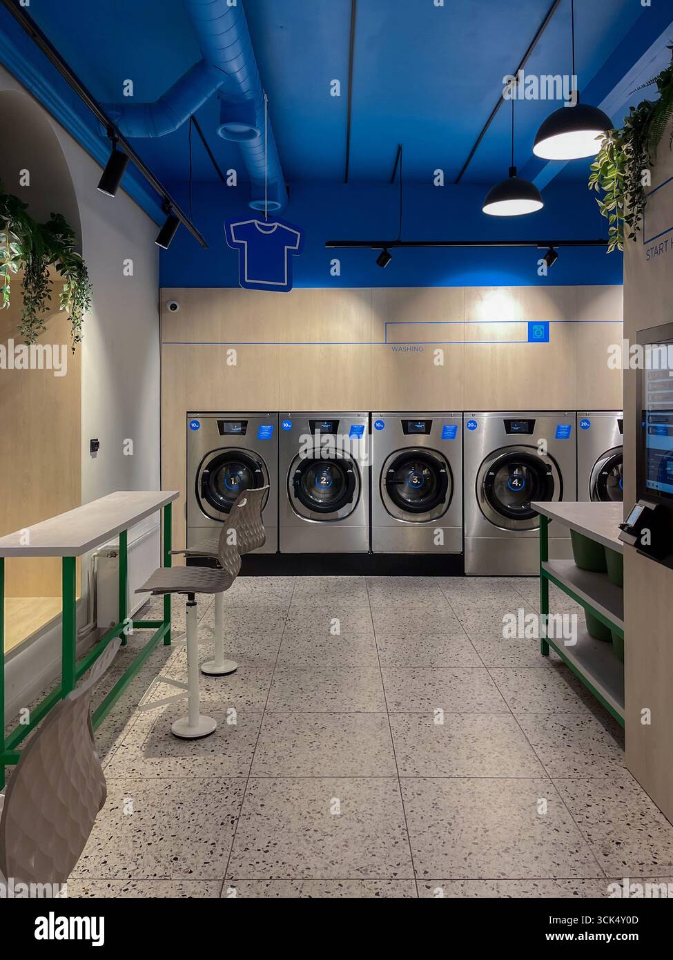 Riga, Lettonia - 4 settembre 2025: Moderna lavanderia con lavatrici Speed Queen, aree self-service e un'estetica pulita e moderna con vi Foto Stock