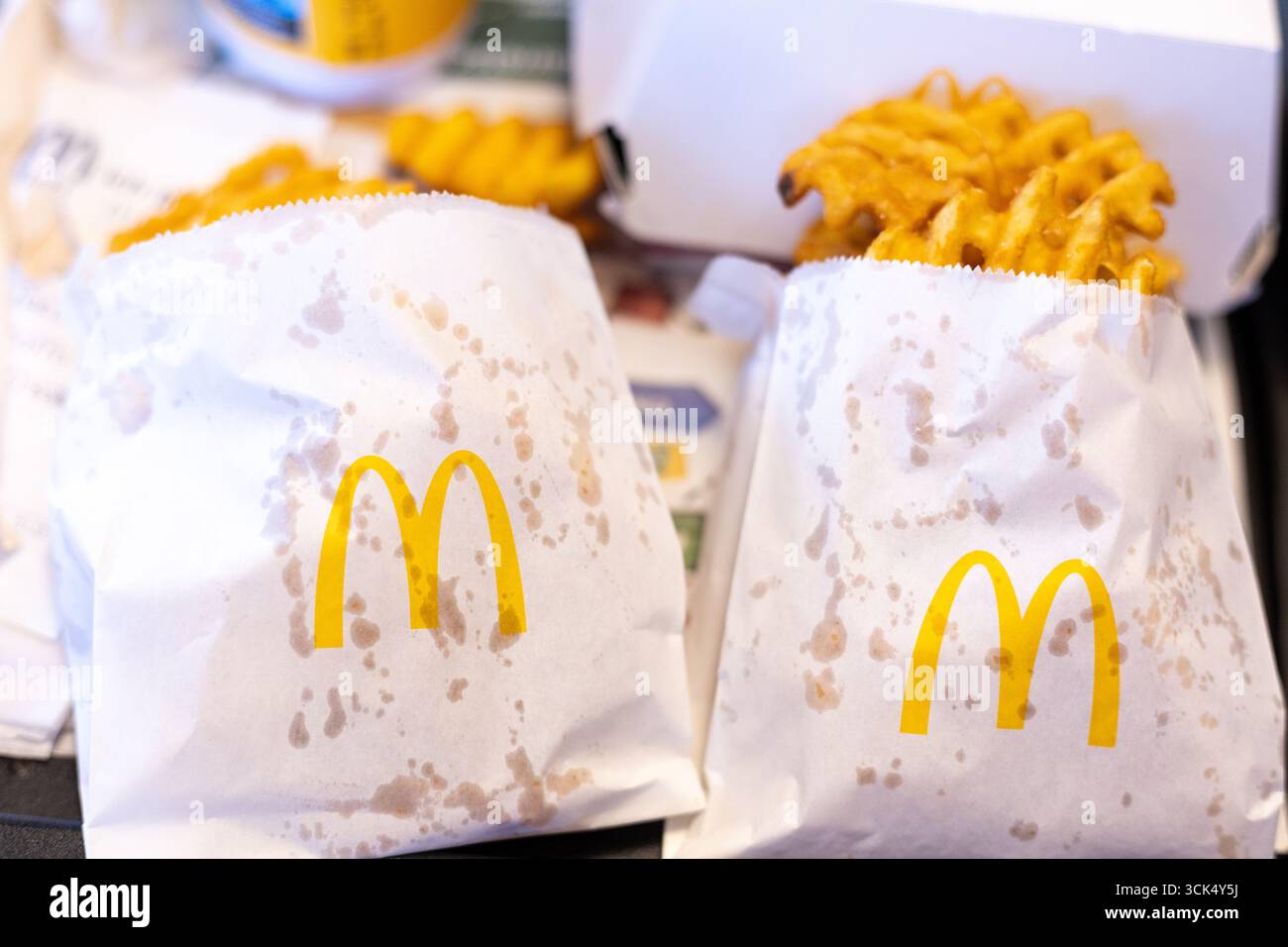 Kerpen, Germania - 9 agosto 2025: Patatine fritte in sacchetti di carta con marchio McDonalds su vassoio Foto Stock