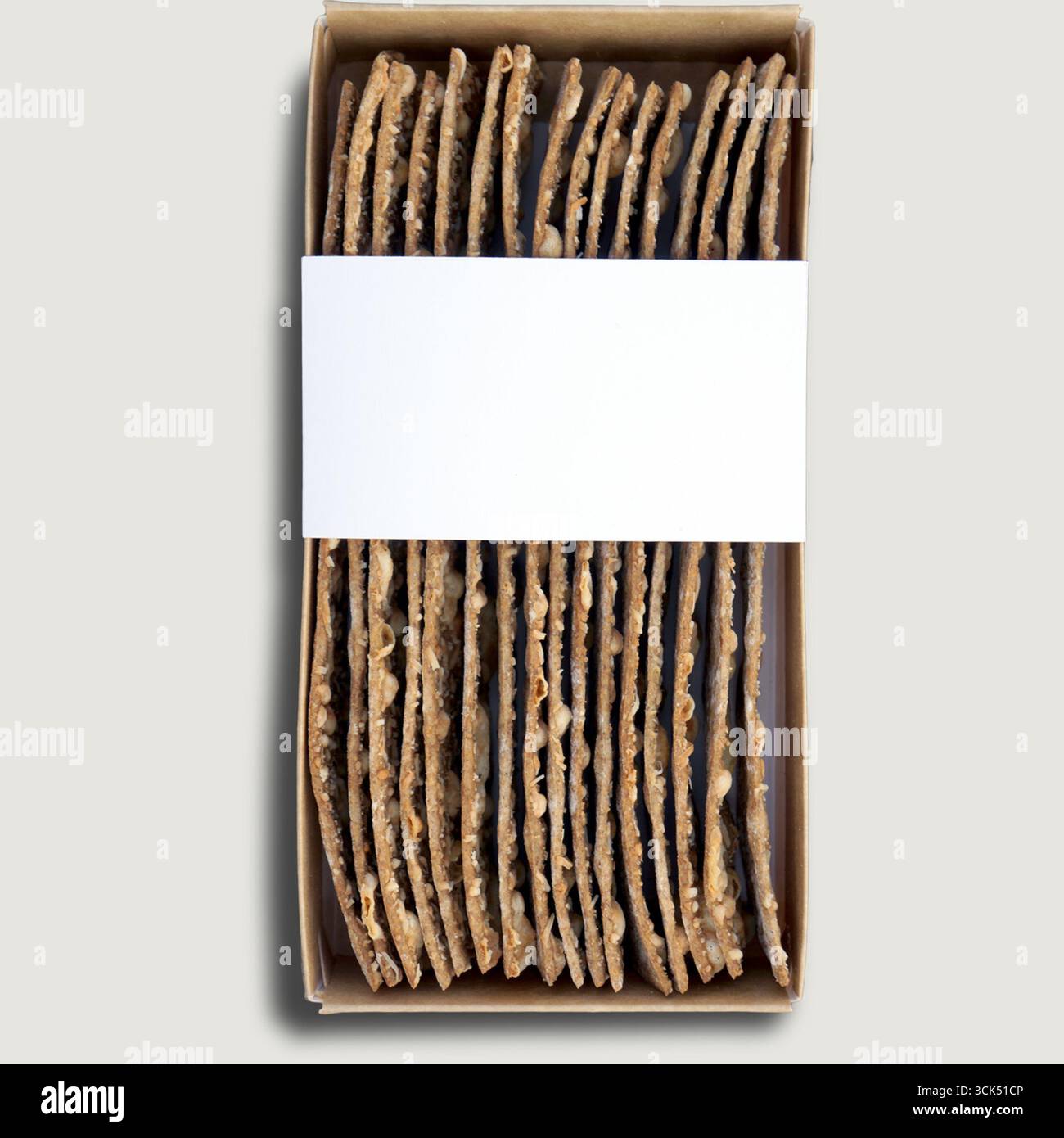 Una scatola contenente pane piatto o cracker disposti in modo ordinato, pronti per l'imballaggio o la vendita. Foto Stock
