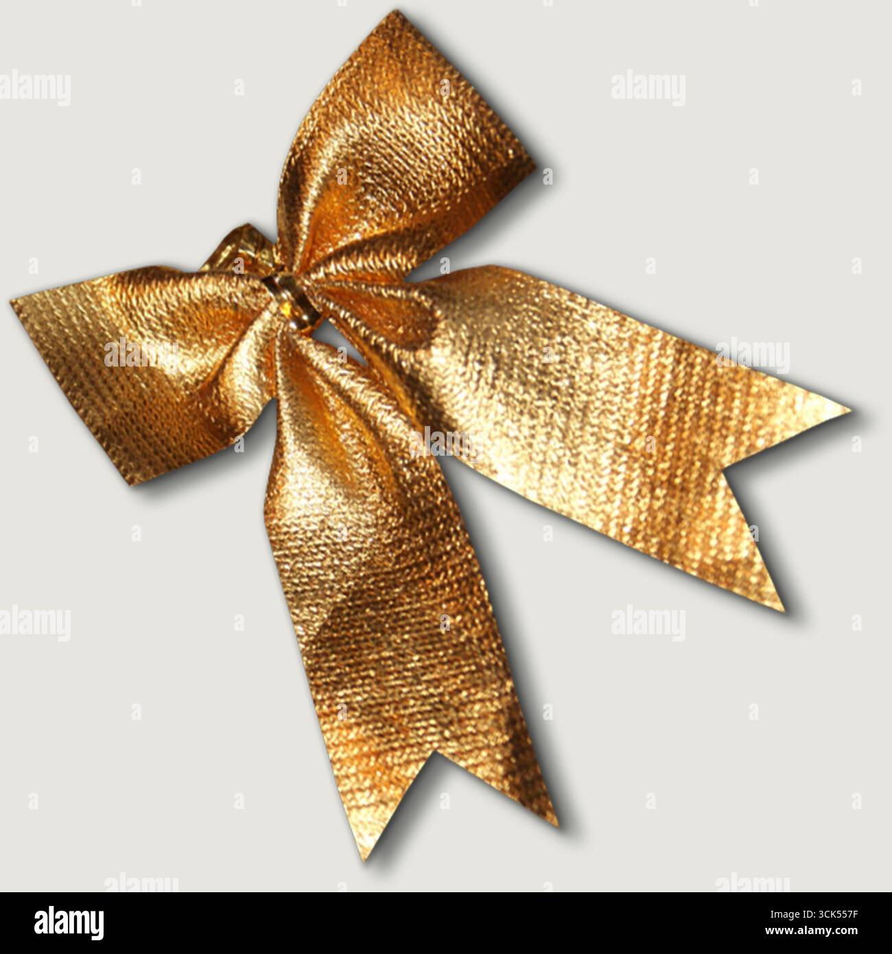 Un fiocco dorato lucido, spesso utilizzato per l'imballaggio regalo o per scopi decorativi. Foto Stock