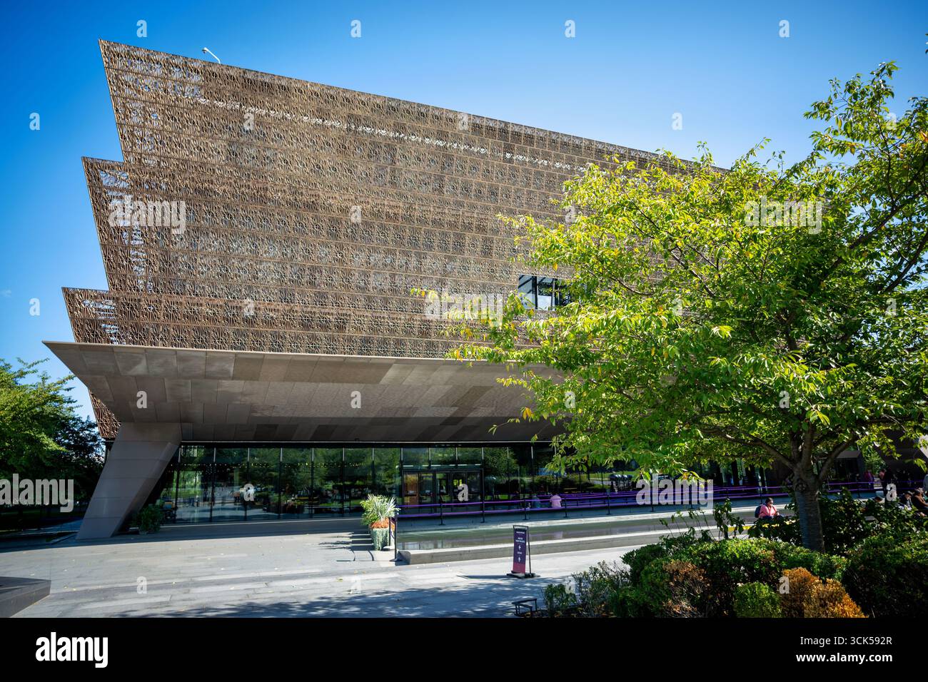 National Museum of African American History and Culture Washington DC // WASHINGTON DC — il National Museum of African American History and Culture, un'istituzione Smithsonian, è un esempio impressionante di architettura contemporanea con la sua facciata color bronzo simile a un reticolo. Progettato da David Adjaye e Philip Freelon, il design dell'edificio trae ispirazione dalle corone yorubane e dalle opere in ferro delle persone schiavizzate. Situato sul National Mall, è stato inaugurato nel 2016 ed è dedicato a documentare la vita, la storia e la cultura afroamericana. Il museo ospita una vasta collezione di manufatti ed esposizioni Foto Stock
