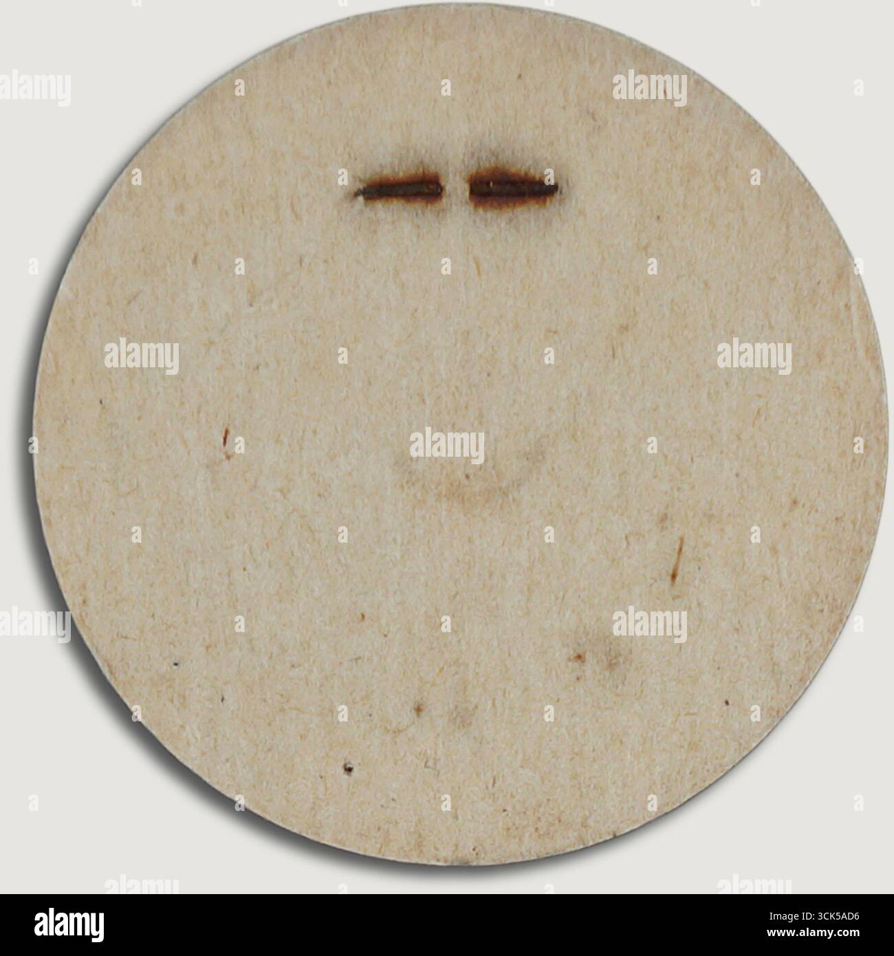 Un semplice cerchio di legno con un design minimalista del volto, caratterizzato da due linee orizzontali per gli occhi e un sottile sorriso. Foto Stock