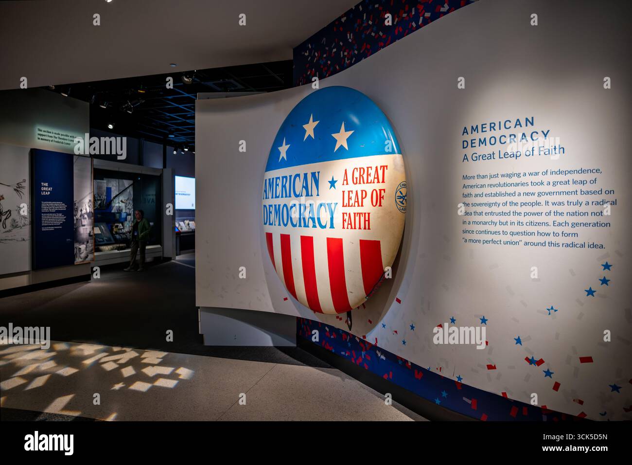 Lo Smithsonian National Museum of American History American Democracy Exhibit Washington DC | WASHINGTON D.C., Stati Uniti - Una gigantesca scultura con pulsanti campagna che recita "American Democracy A Great Leap of Faith" è il punto di riferimento di questa galleria presso lo Smithsonian's National Museum of American History. La mostra ripercorre circa due secoli e mezzo di partecipazione e dibattito dei cittadini, inquadrando la scelta dei fondatori di porre la sovranità nel popolo piuttosto che un monarca come una scommessa deliberata. Coriandoli e motivi stellari sulle pareti circostanti riecheggiano le immagini delle campagne politiche americane. Foto Stock
