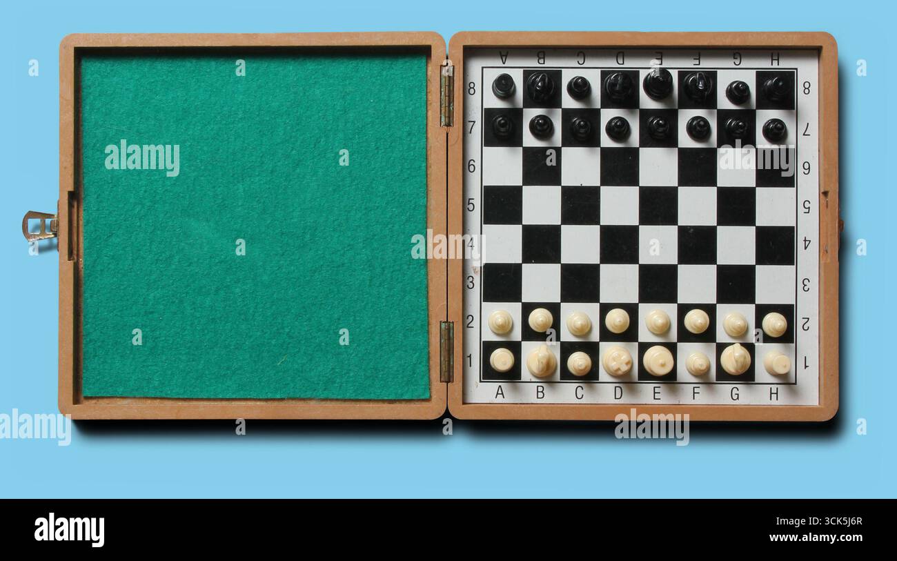 Una scatola di legno per scacchi con una scacchiera a scacchi e pezzi disposti per una partita. Foto Stock