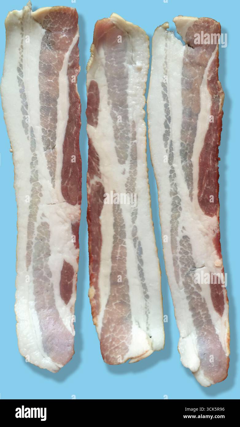 Tre strisce di pancetta cruda che mostrano strati di grasso e carne. Foto Stock