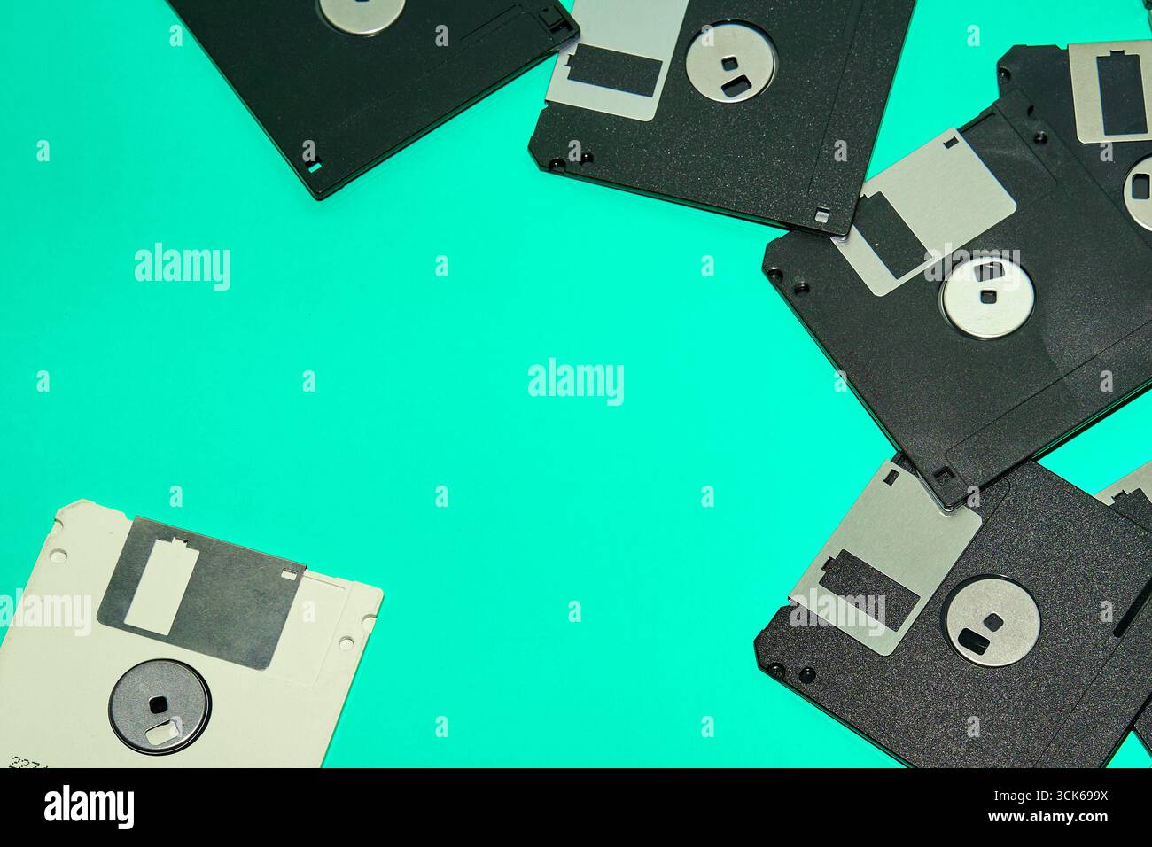 Una raccolta di vecchi floppy disk, reliquie del computing degli anni '90, su sfondo turchese Foto Stock