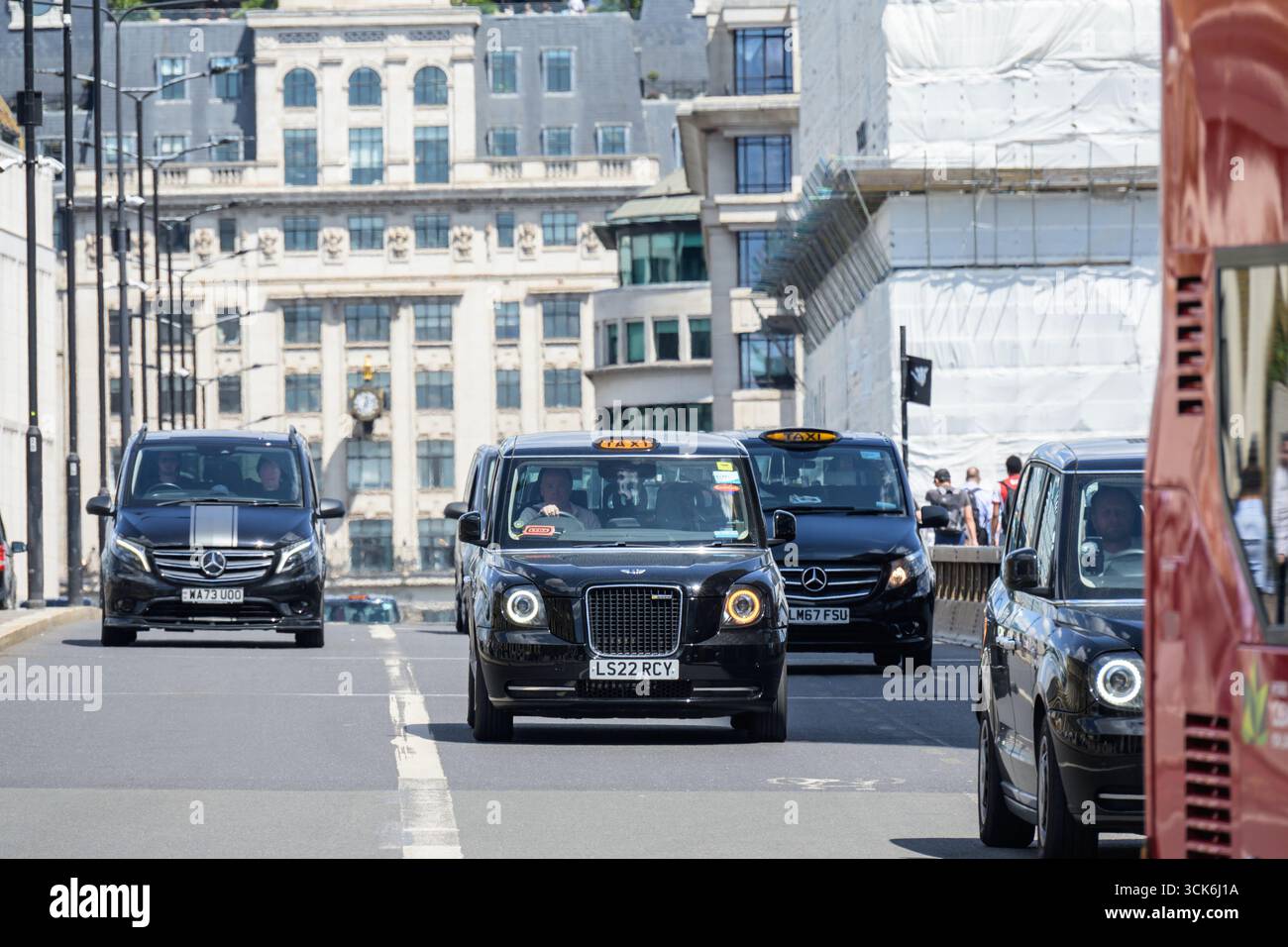 Londra, Regno Unito. Taxi neri di Londra che attraversano il London Bridge, visto da sud. Foto Stock