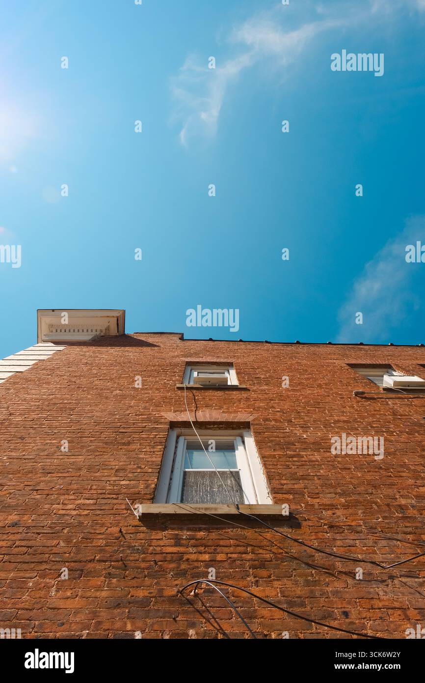 Affacciato su un vecchio edificio in mattoni dal cielo blu brillante Foto Stock Affacciato su un vecchio edificio in mattoni dal cielo blu brillante Foto Stock