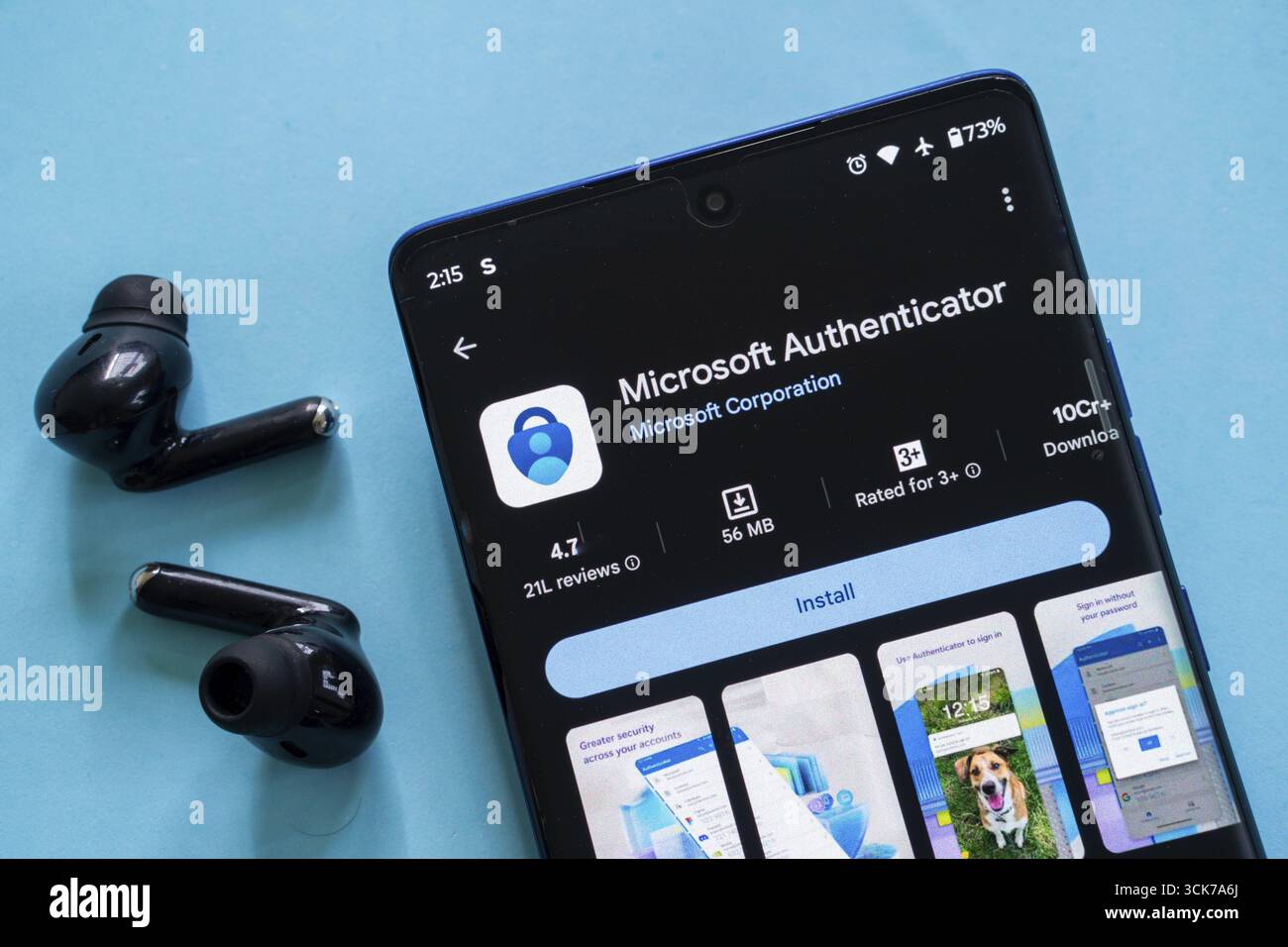 Lo smartphone mostra la pagina di download dell'app Microsoft Authenticator con gli auricolari nelle vicinanze Foto Stock
