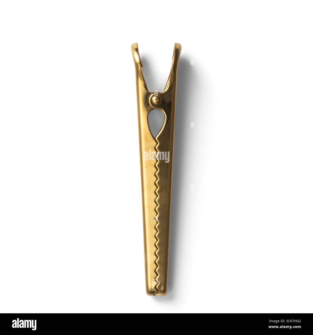 Un clothespin dorato progettato per appendere abiti o oggetti da asciugare. Foto Stock