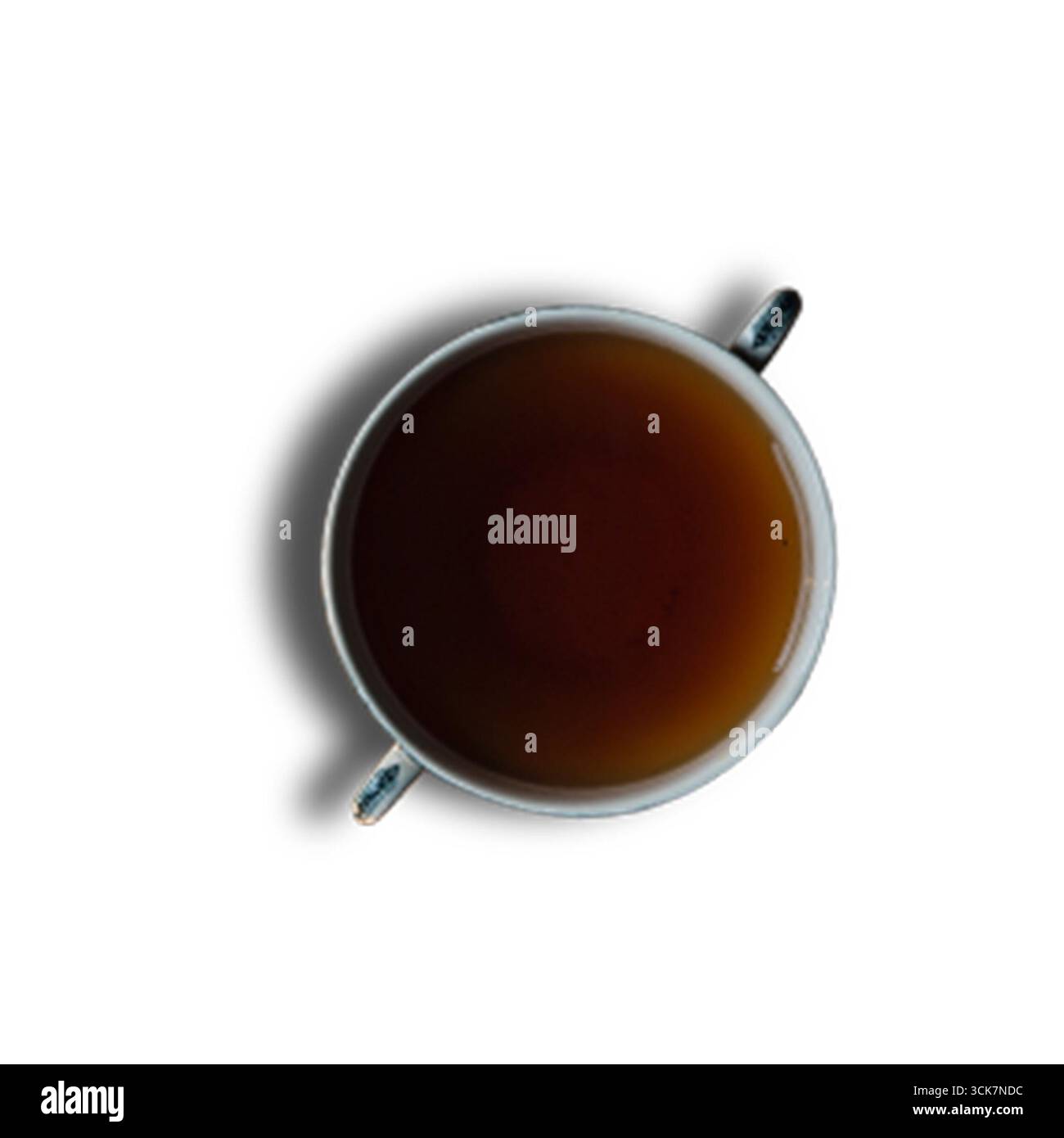 Vista dall'alto verso il basso di una tazza riempita di liquido scuro, probabilmente tè o caffè, su uno sfondo bianco. Foto Stock