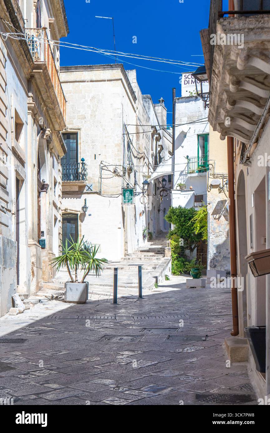 Una foto di edifici tra vicoli in pietra e balconi mediterranei nel centro storico sotto un cielo blu, nell'Italia meridionale. Grottaglie (Puglia, Italia) Foto Stock