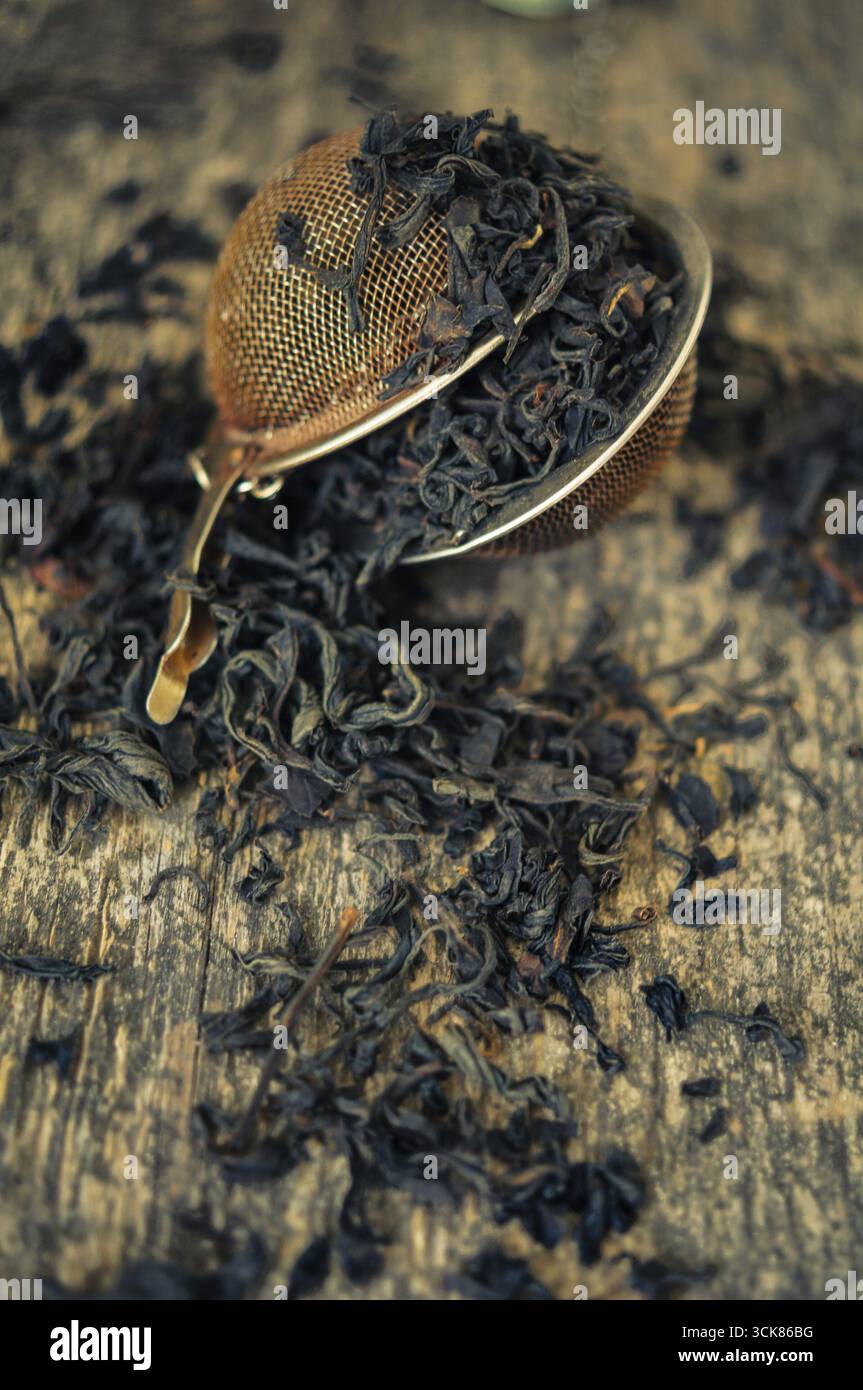 Coloratori di tè con tè aromatico su sfondo di legno Foto Stock
