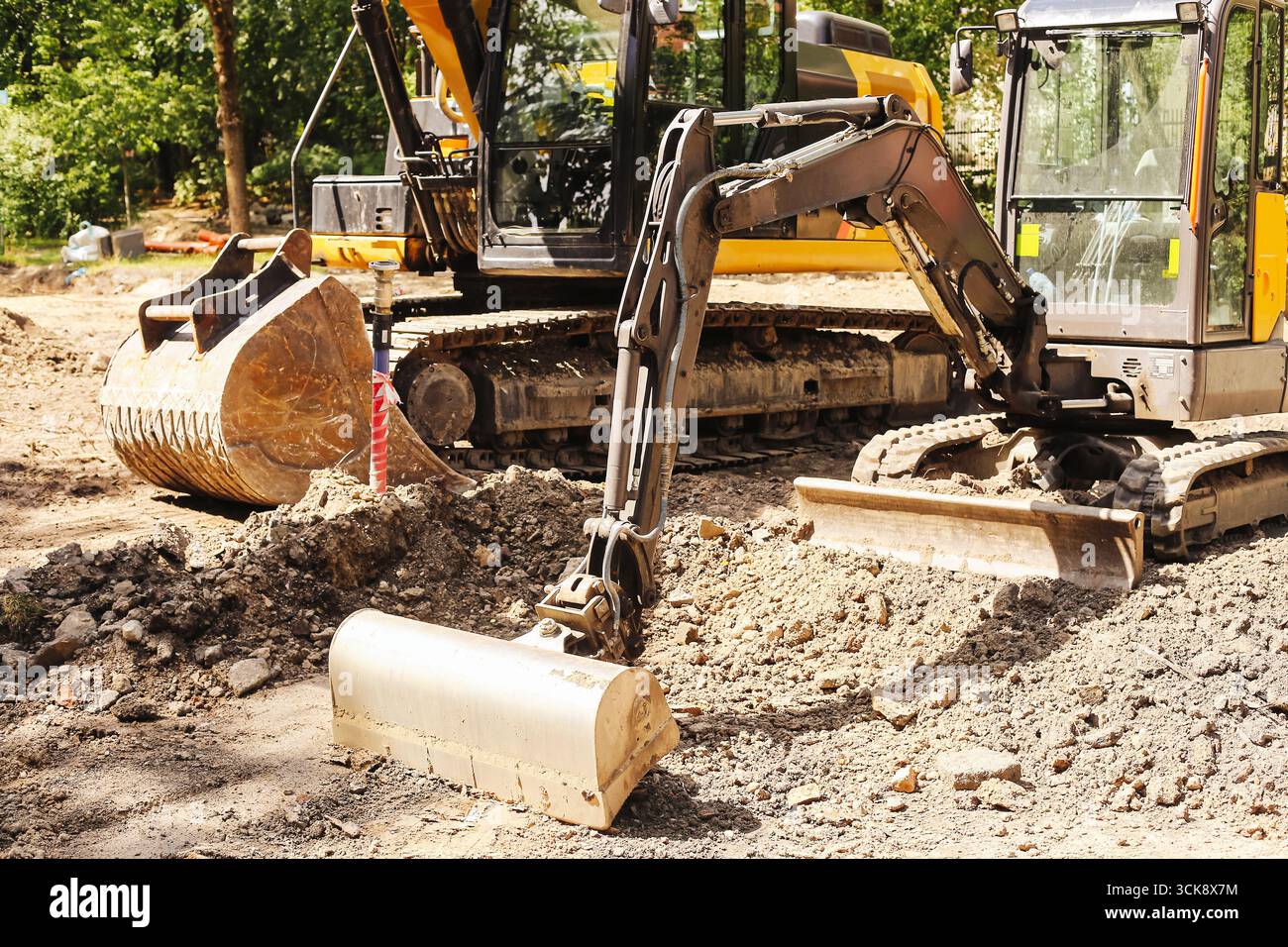 Escavatore in fase di costruzione. Macchinari pesanti per lo scavo del terreno. Apparecchiature industriali di movimento terra per la costruzione di strade e lo sviluppo di infrastrutture Foto Stock
