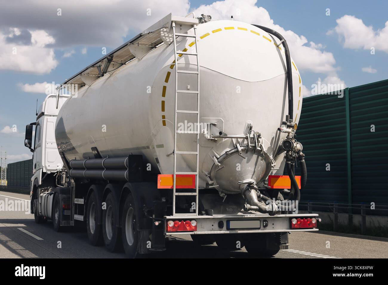 Autocisterna su strada. Veicolo industriale per il trasporto di liquidi. Rimorchio per carichi di grandi dimensioni dal design moderno. Concetto di logistica e spedizione. Foto Stock