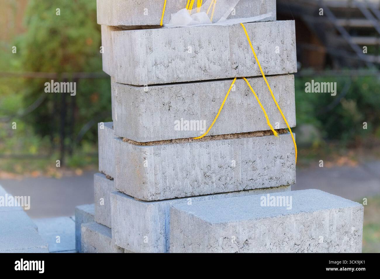 Blocchi grigi per il percorso pedonale. Pietre per pavimentazione marciapiede impilate. Testurizzati e pronti per la costruzione. Materiale da costruzione. Costruzione di edifici. Foto Stock