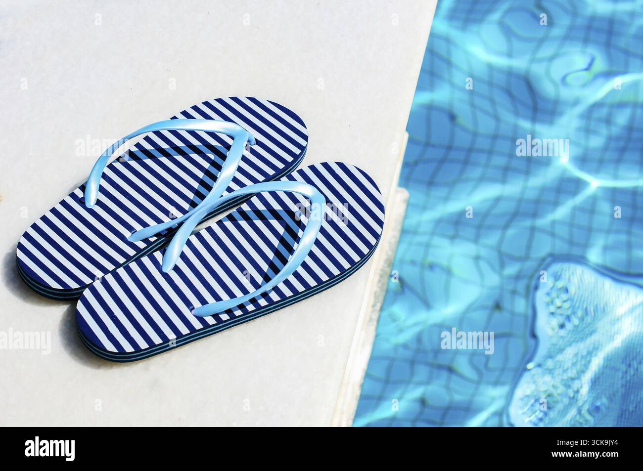 Scarpe estive infradito a righe a bordo piscina Foto Stock