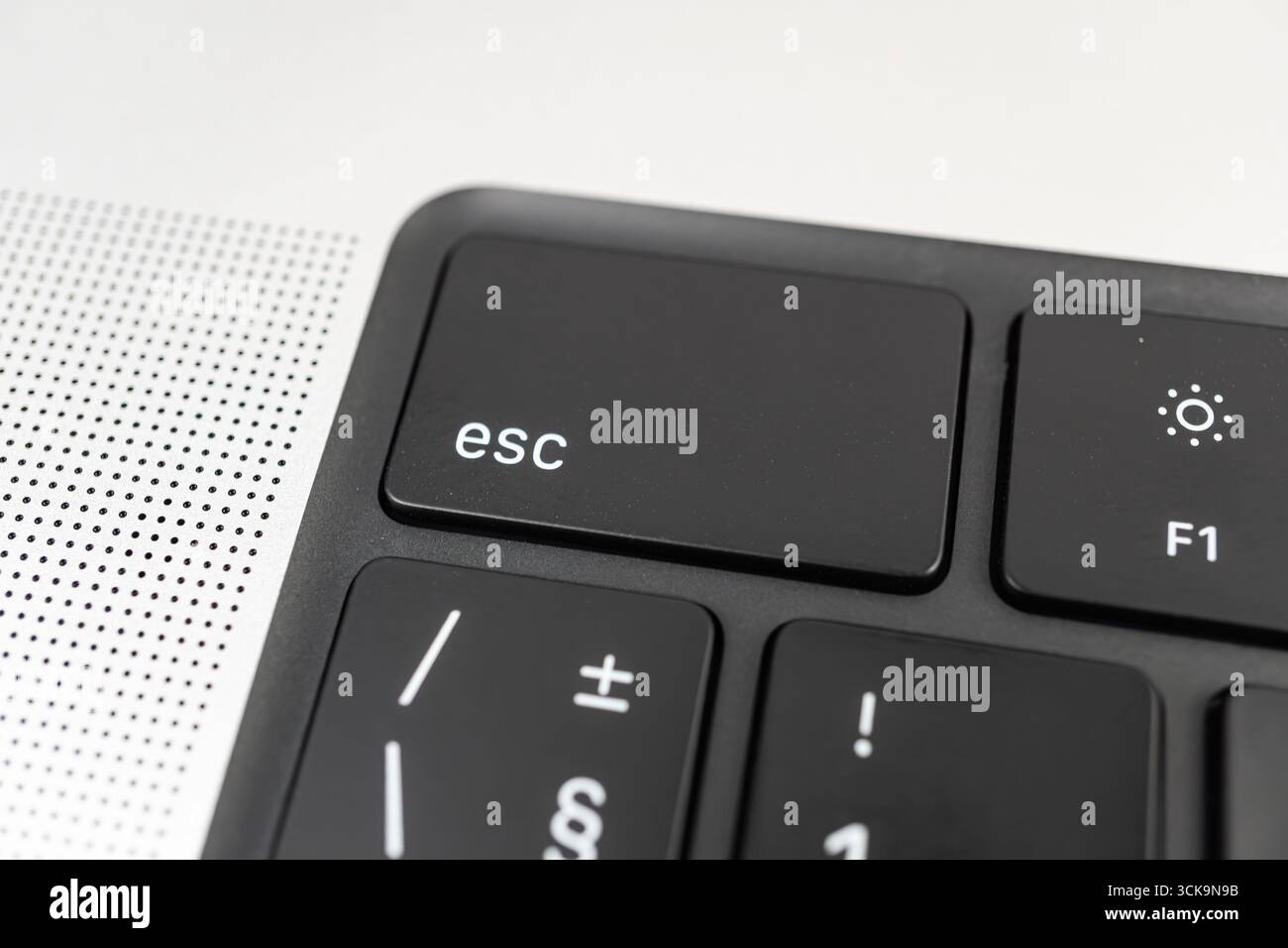 Primo piano di una tastiera moderna e minimalista per laptop, con particolare attenzione ai tasti funzione contrassegnati dal tasto ESC F1-F12 e al layout del tastierino numerico Foto Stock