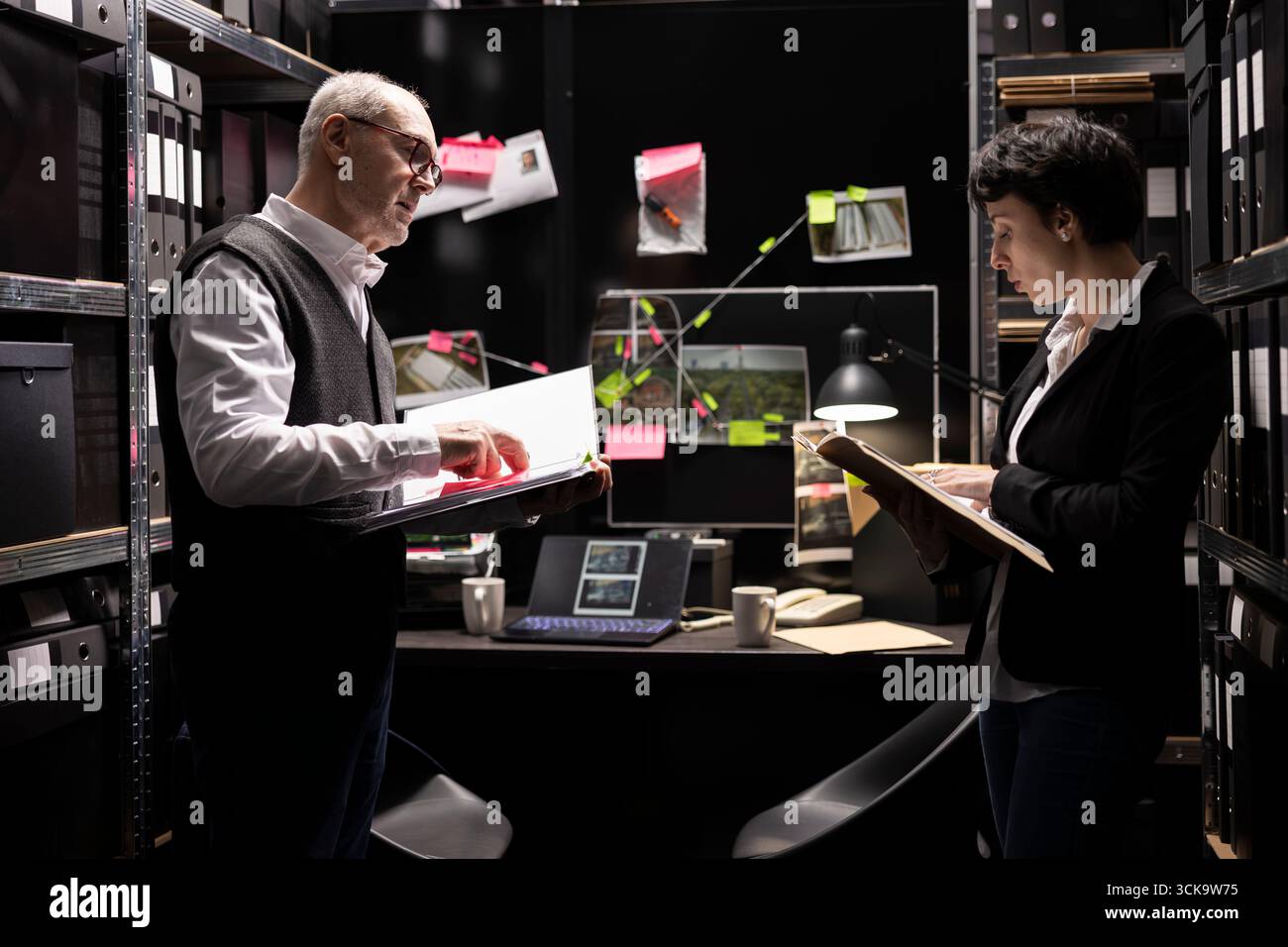 Investigatori privati che ordinano i fascicoli riservati e raccolgono informazioni per risolvere un'operazione criminale illegale. Colleghi che collegano le prove per una missione di polizia segreta. Foto Stock