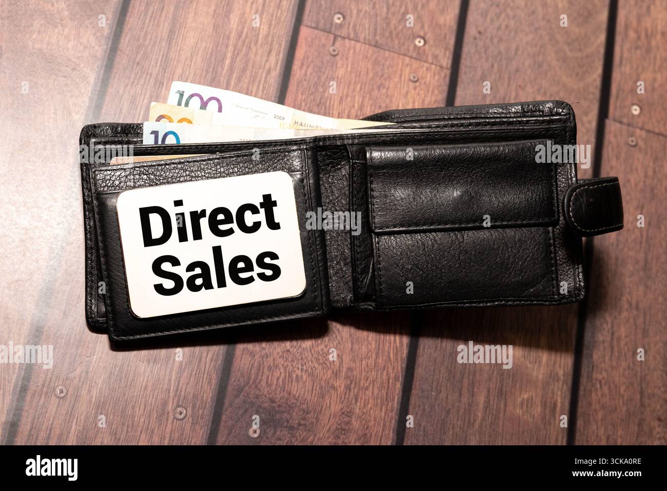 Concetto di business e finanza. Su sfondo rosso, ingranaggi e un piano di pensiero con l'iscrizione - VENDITE DIRETTE Foto Stock