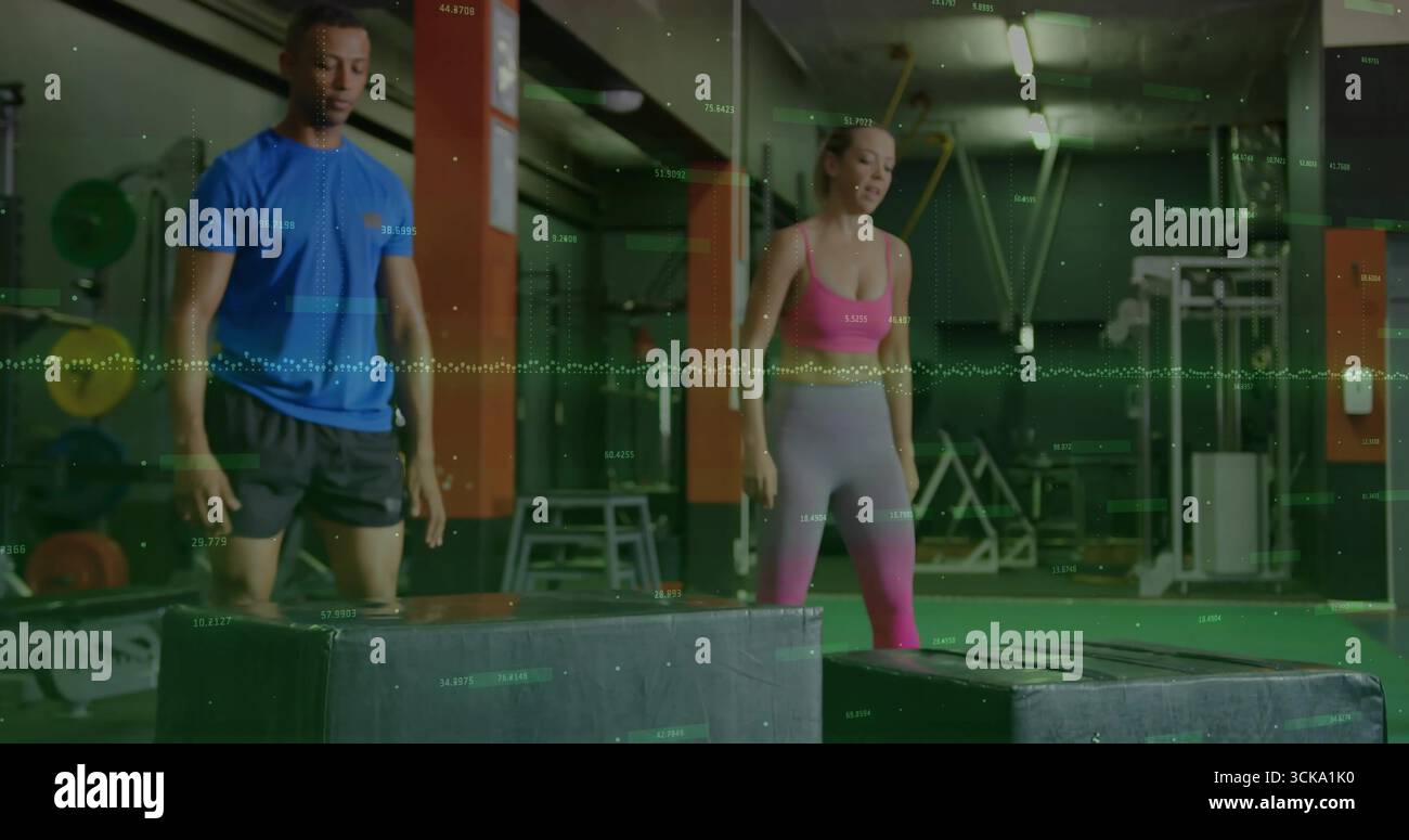 Partner di formazione che eseguono salti in palestra, con scatole plyometriche e grafica delle prestazioni Foto Stock