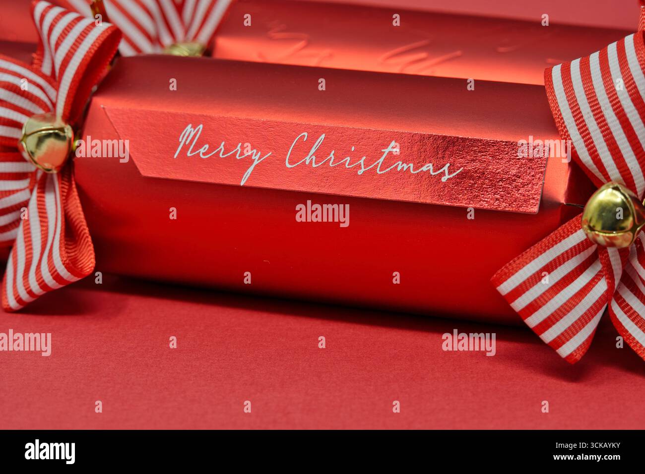 Cracker natalizi rossi festivi con nastri decorativi e auguri natalizi Foto Stock