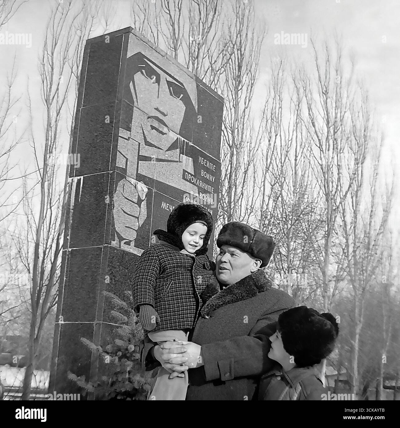 Veterano della grande Guerra Patriottica con i suoi nipoti in un memoriale a Sloviansk, RSS Ucraina, nel 1980. La fotografia d'archivio cattura un momento toccante e personale del "legame delle generazioni", mentre il nonno tiene in braccio il nipote più giovane mentre gli racconta la storia del monumento. Questa scena, piena di calore e cura, simboleggia il trasferimento della famiglia e della memoria storica della guerra come una testimonianza per preservare la pace per le generazioni future durante l'era del socialismo sviluppato Foto Stock