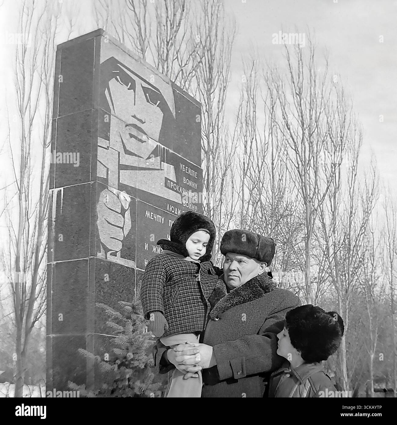 Veterano della grande Guerra Patriottica con i suoi nipoti in un memoriale a Sloviansk, RSS Ucraina, nel 1980. La fotografia d'archivio cattura un momento toccante e personale del "legame delle generazioni", mentre il nonno tiene in braccio il nipote più giovane mentre gli racconta la storia del monumento. Questa scena, piena di calore e cura, simboleggia il trasferimento della famiglia e della memoria storica della guerra come una testimonianza per preservare la pace per le generazioni future durante l'era del socialismo sviluppato Foto Stock