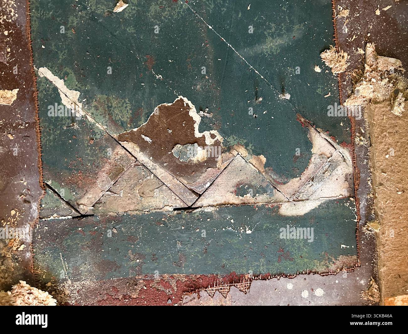 vecchia spina di pesce danneggiata, parquet in dettaglio, coperta da un vecchio linoleum marcio pronto per la ristrutturazione Foto Stock