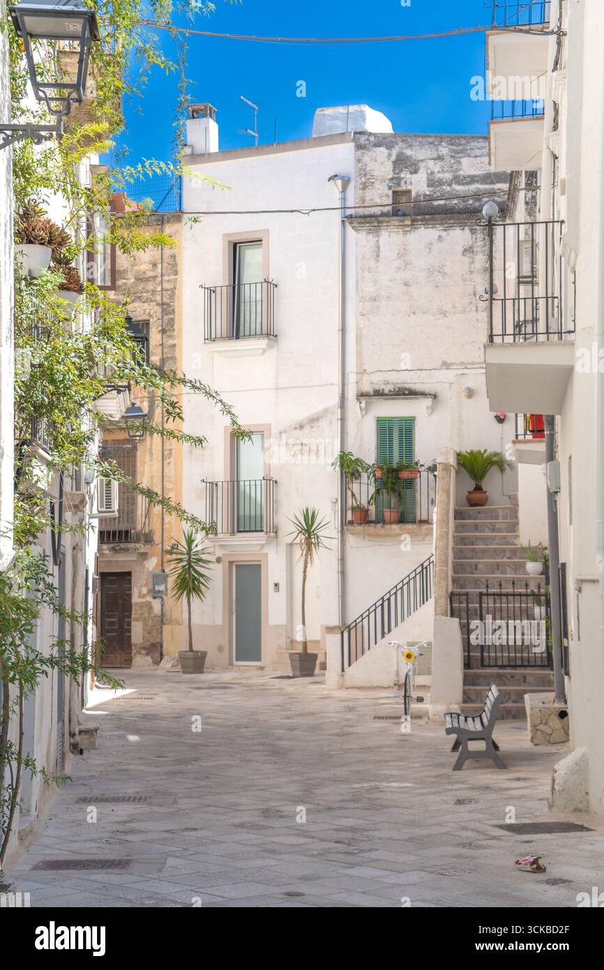 Una foto di edifici tra vicoli in pietra e balconi mediterranei nel centro storico sotto un cielo blu, nell'Italia meridionale. Grottaglie (Puglia, Italia) Foto Stock