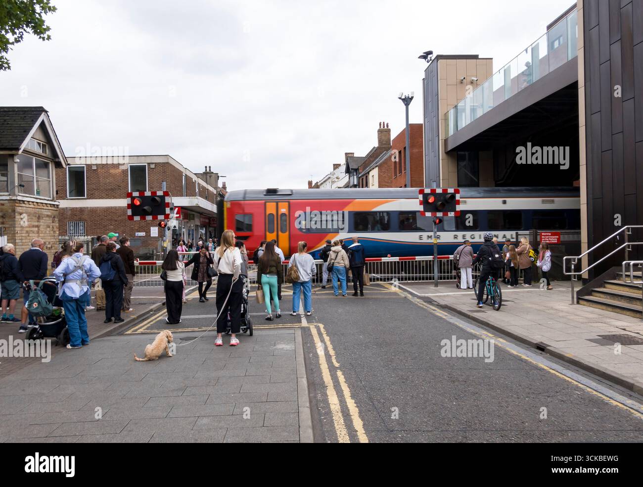 Treno passeggeri regionale East Midlands che attraversa High Street a velocità sostenuta, Lincoln City, Lincolnshire, Inghilterra, Regno Unito Foto Stock