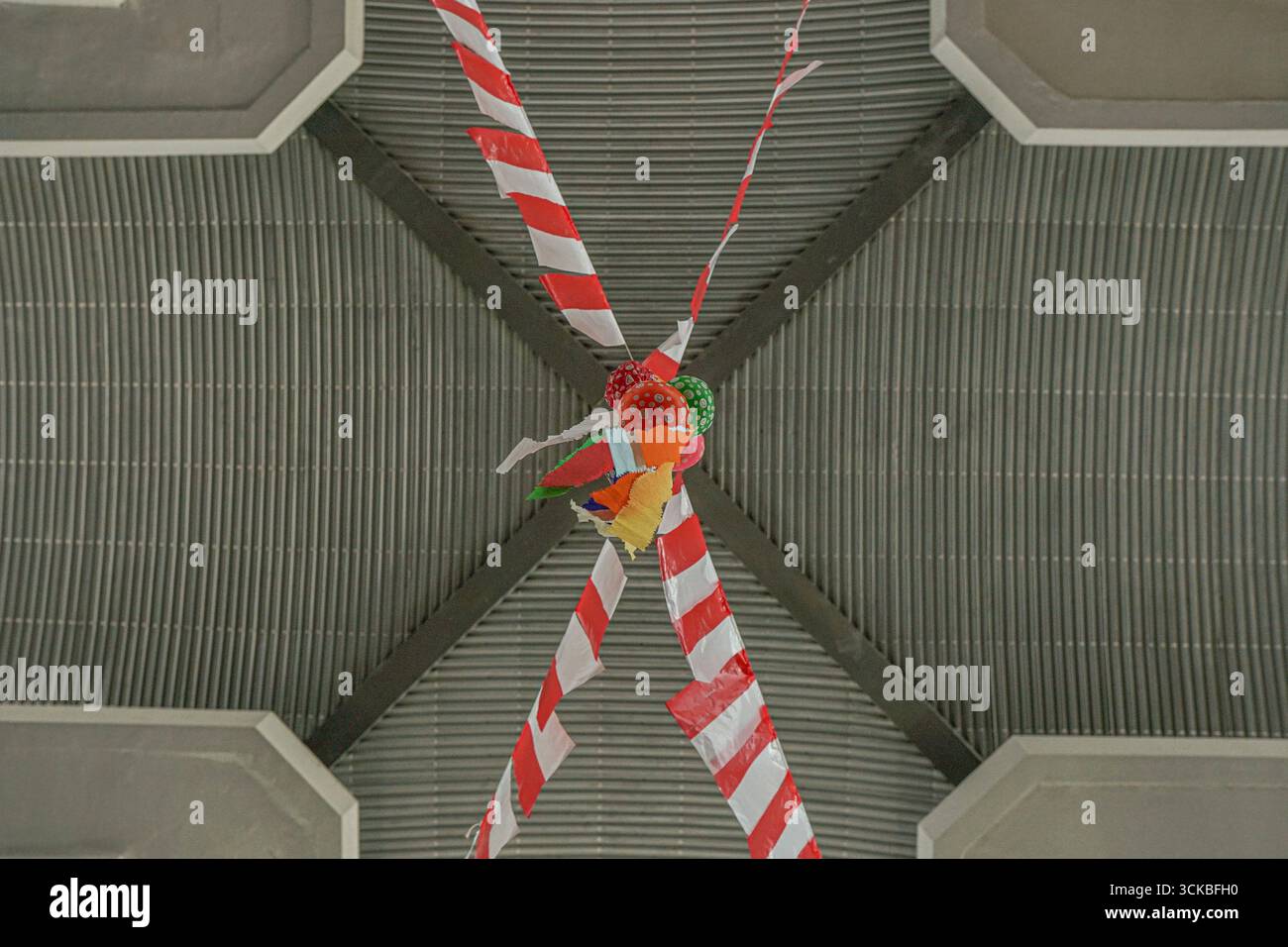 Pinata colorata appesa al soffitto con nastri a righe. Foto Stock