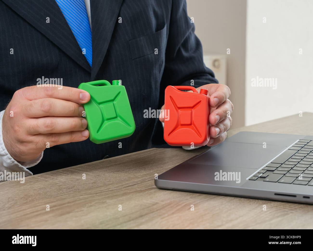 Uomo d'affari che possiede taniche di combustibili fossili e verdi. Concetto di transizione verde, energia pulita, politica ambientale e standard industriali. Utilizzato per Foto Stock