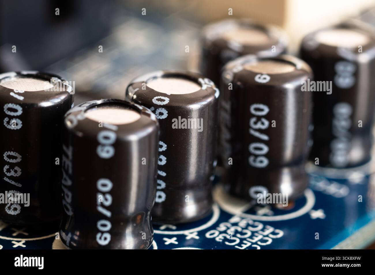 Primo piano su un gruppo di condensatori sulla scheda madre del computer e sui componenti hardware Foto Stock
