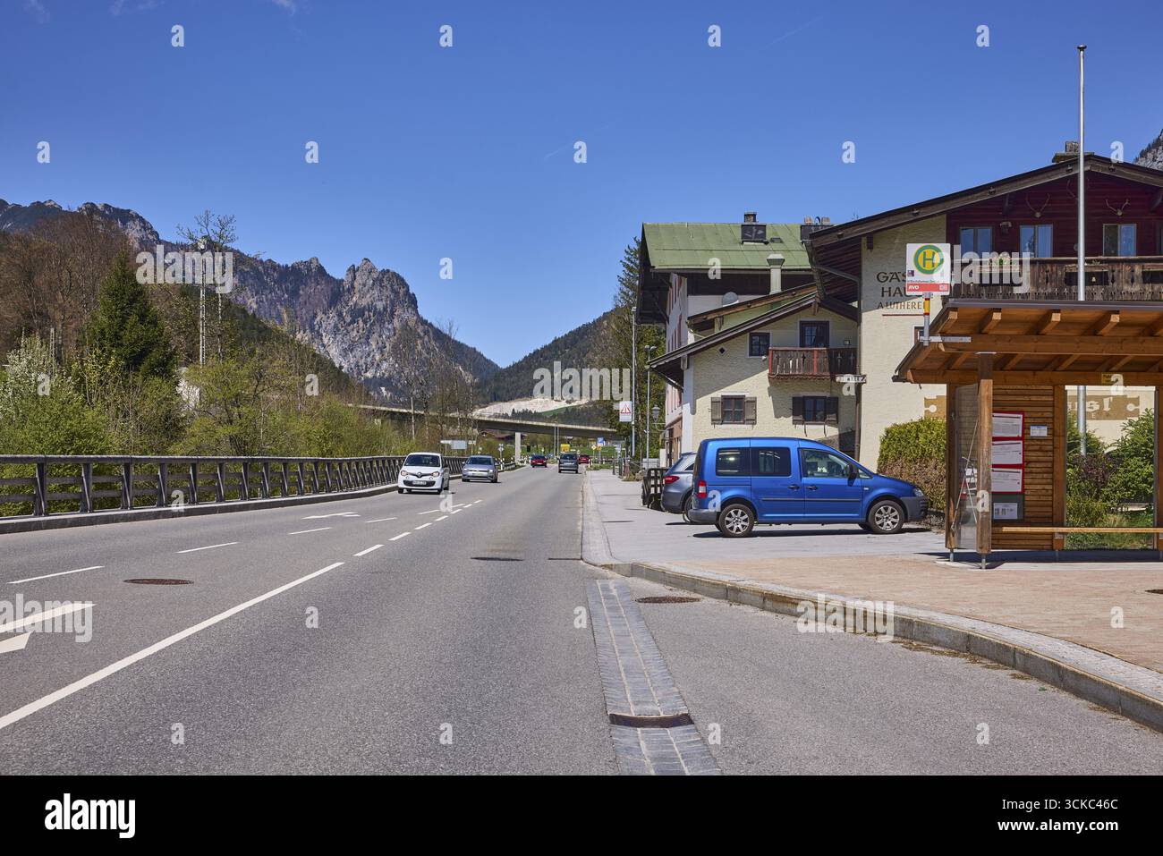Fermata dell'autobus Bischofswiesen centro, strada, architettura generale, veicoli, montagne, paesaggio montano, alberi, cielo blu, senza nuvole, strada federale 20, bip Foto Stock