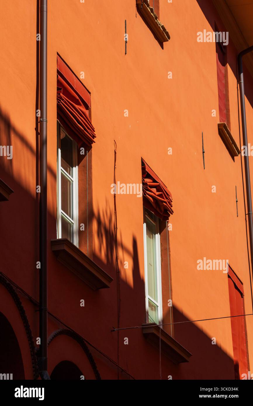 Facciata arancione con sfumature rosse e motivi d'ombra Foto Stock