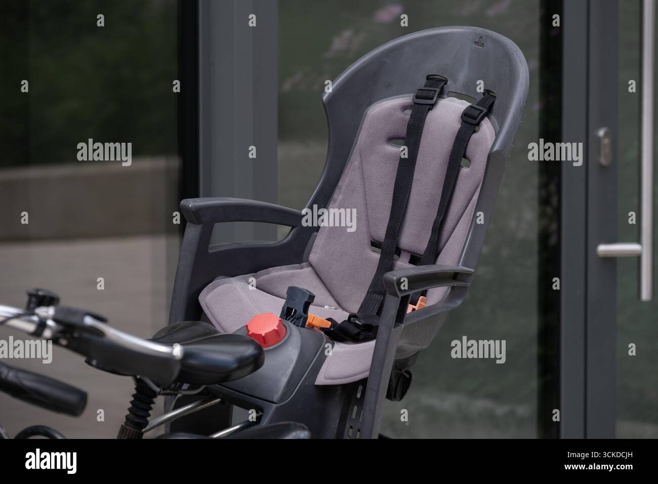Primo piano di un seggiolino per bicicletta per bambini dotato di imbracatura di sicurezza, montato sul retro di una bicicletta per adulti. L'immagine sottolinea la sicurezza dei bambini, famiglia cy Foto Stock