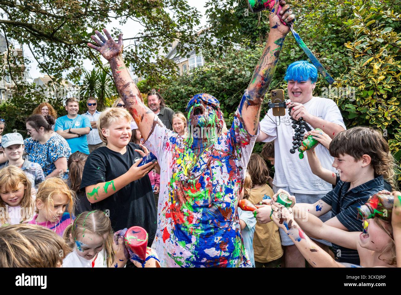 L'artista Graham Cullis è stato dipinto da bambini in un festival d'arte a Newquay in Cornovaglia in Inghilterra nel Regno Unito. Foto Stock